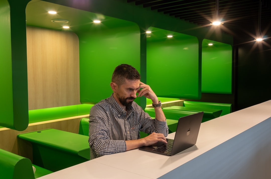 a man sitting at a table using a laptop computer